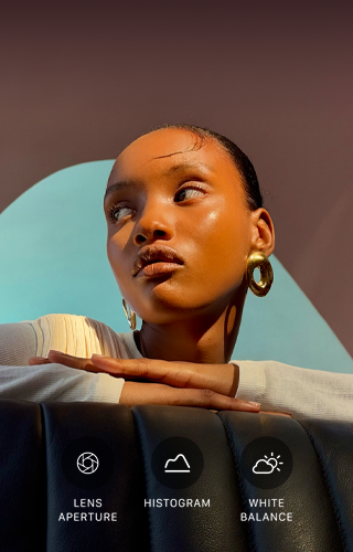 Close-up portrait of a well-lit model with a colourful background, demonstrating the pro camera system's Pro controls UI: Aperture, Histogram, White Balance